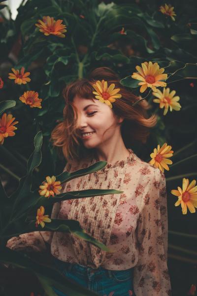 站在鲜花里拍照的微笑少女