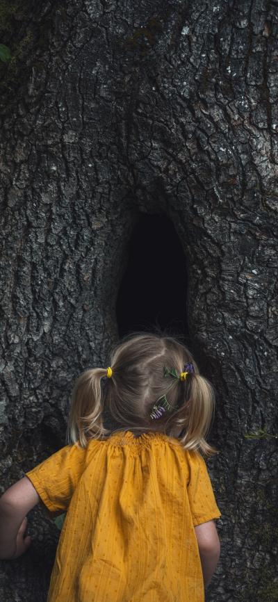 对着树洞说悄悄话的黄衣小女孩