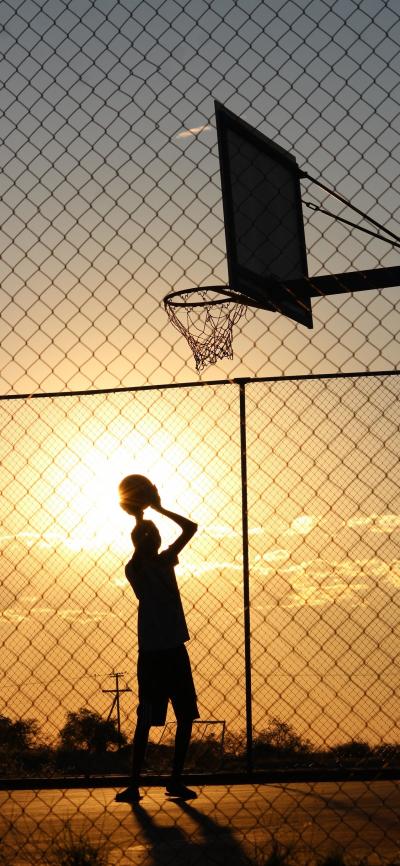 夕阳下篮球场上的男孩子