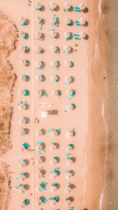 沙滩上排列整齐的遮阳伞和躺椅