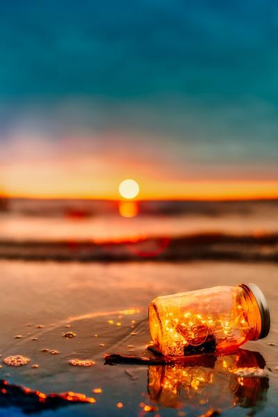 傍晚沙滩上的发光漂流瓶