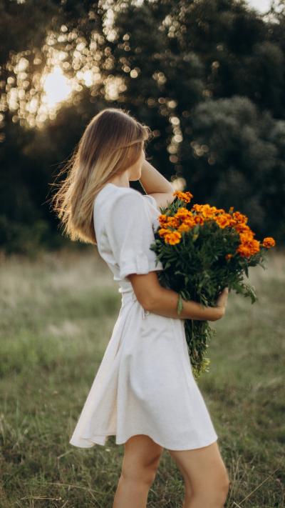 白色长裙美女抱着橙色鲜花