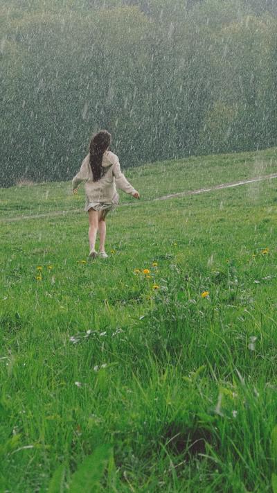 雨中草地上奔跑的女孩背影图片