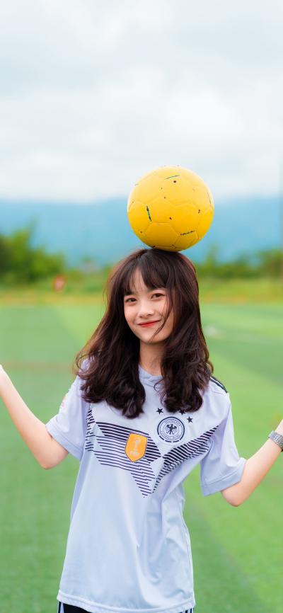 头顶足球的可爱女孩笑容甜美