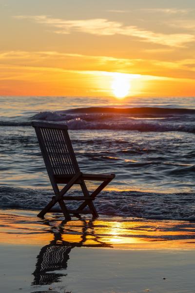 落日海边沙滩上的椅子